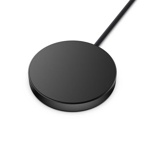 Round black wireless charging pad with a connected cable.
