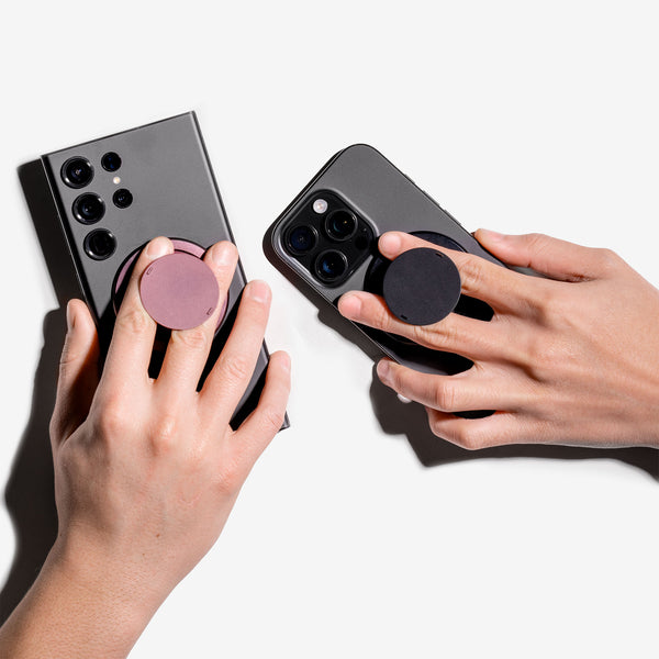 Two smartphones with circular grips attached, held by hands in a light background.