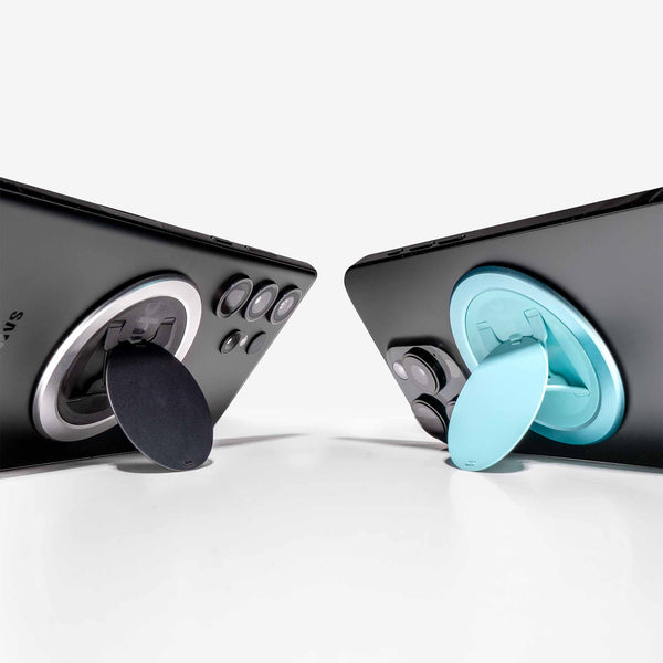 Two smartphone grips in black and teal attached to the back of mobile devices.