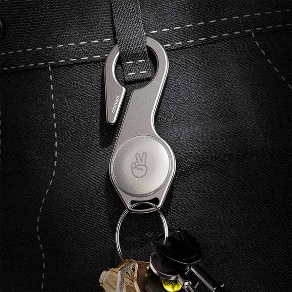 Metal key loop attached to a fabric strap, holding several keys and featuring a peace sign design.