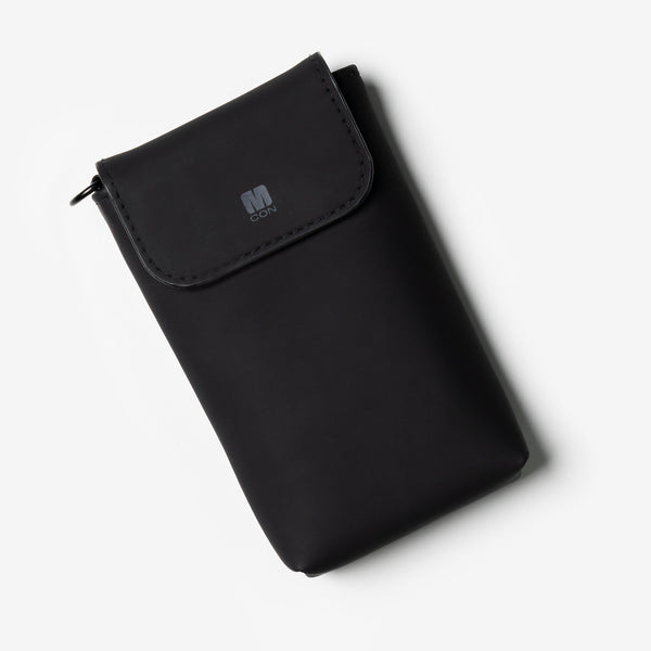 Black travel sleeve with a flap closure and MCON logo on the front.