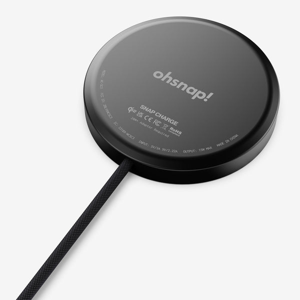 Black circular wireless charger with a textured cable, featuring branding and technical specifications on the surface.