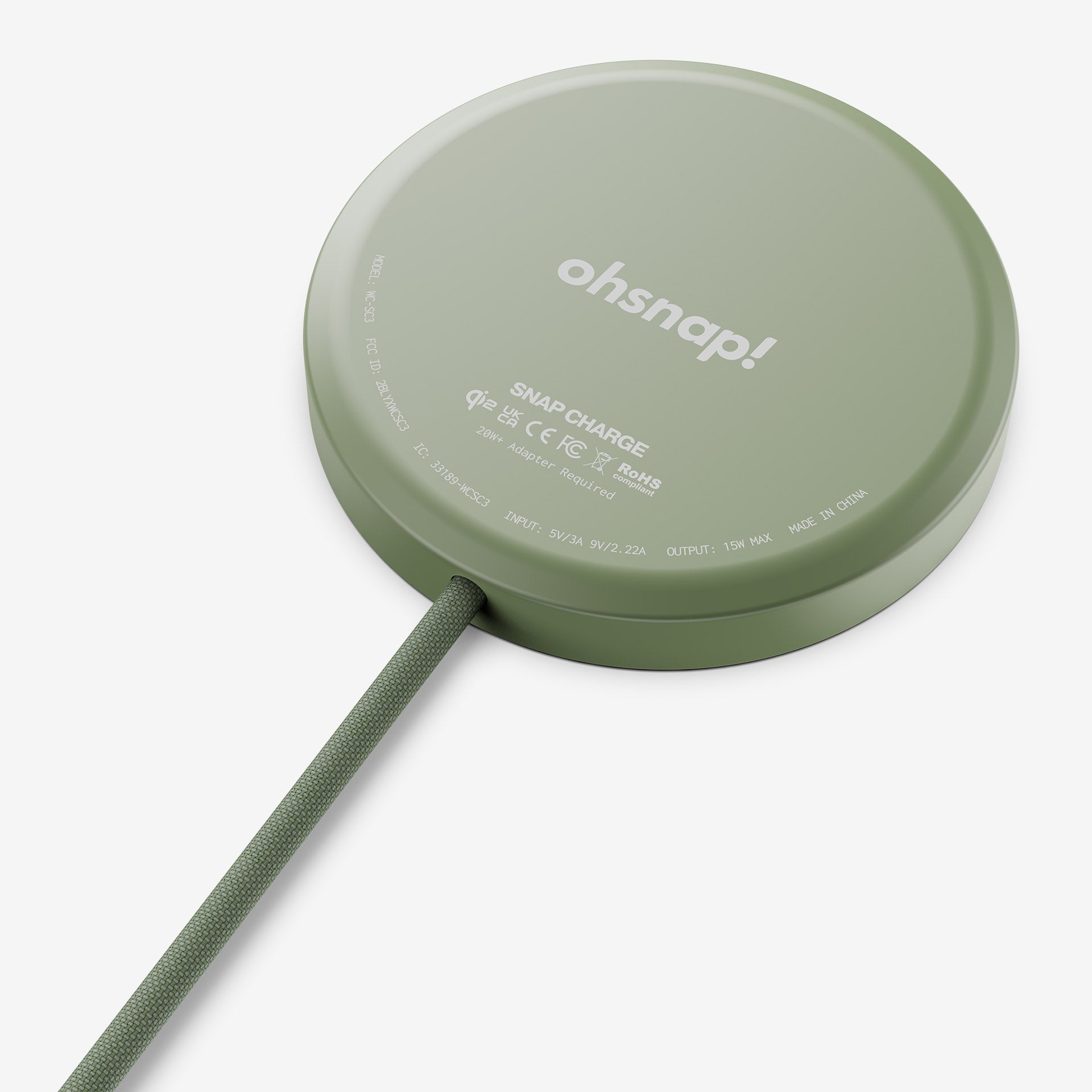 Round green wireless charging pad with a connected cable.