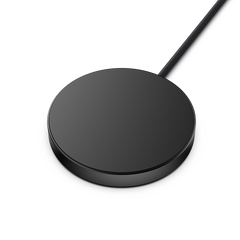 Round black wireless charging pad with a connected cable.