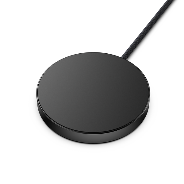 Round black wireless charging pad with a connected cable.