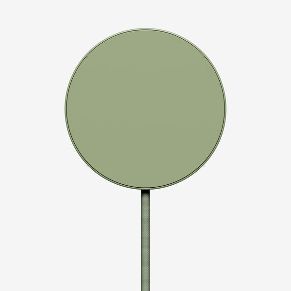Round green wireless charger with a connected cable.