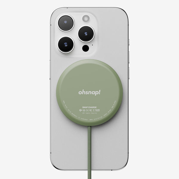 Wireless charger in green attached to a smartphone, with a cable connected to the charger.