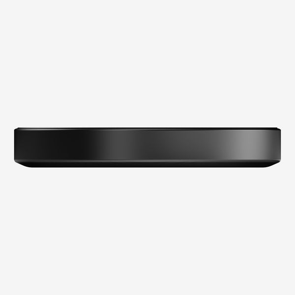 Flat, round black wireless charger with a smooth surface and thin profile.