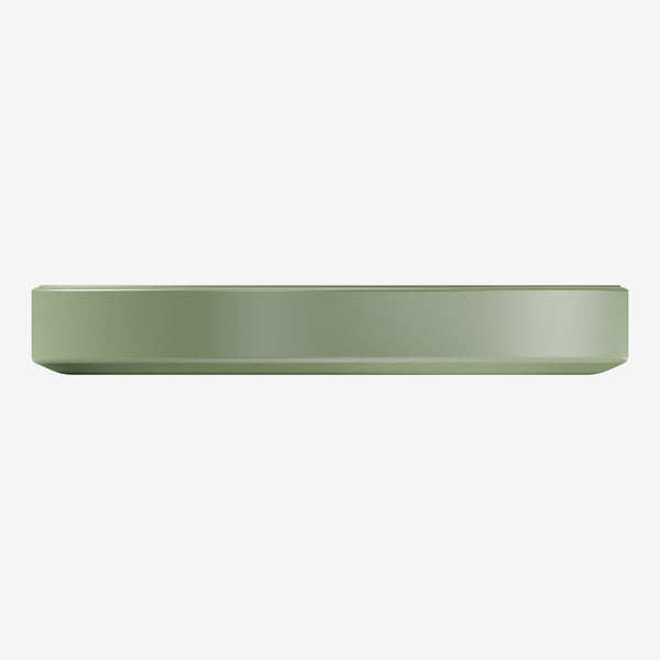 Flat, round wireless charger in a muted green color with a smooth surface.