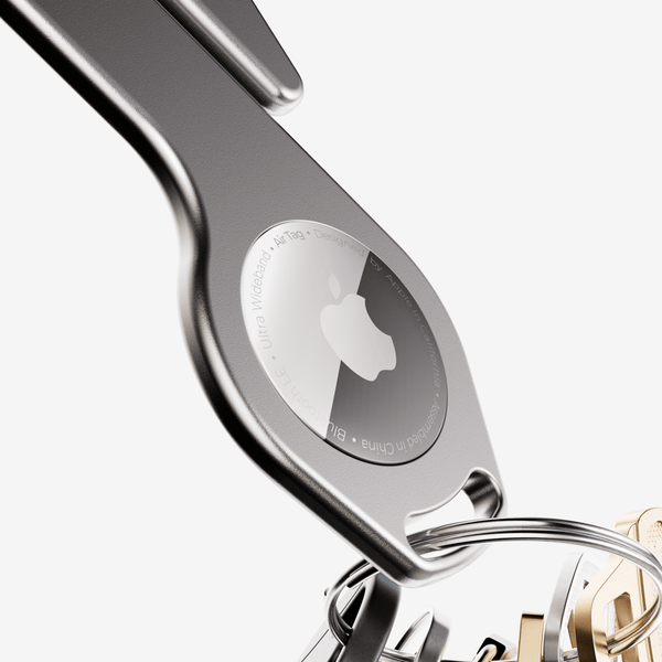 Metal key loop with an Apple logo and attached keyring, designed for holding an AirTag.
