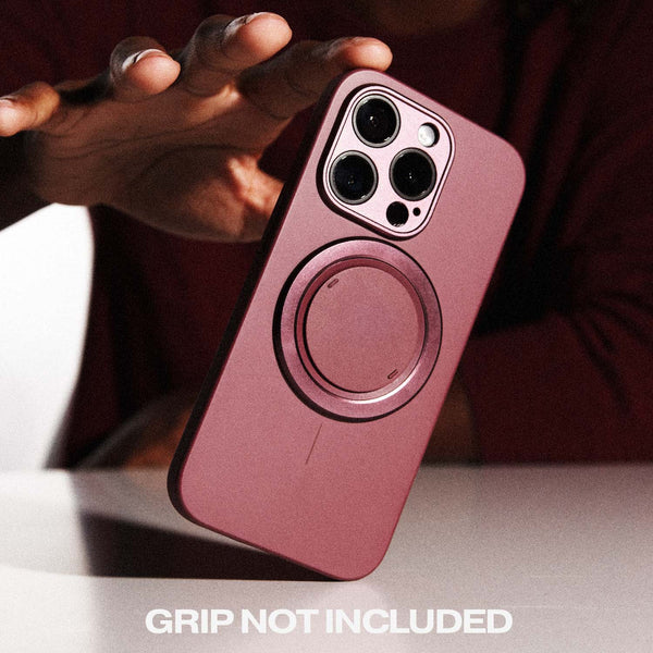 Magenta phone case with a circular attachment area, held above a surface, with text stating 