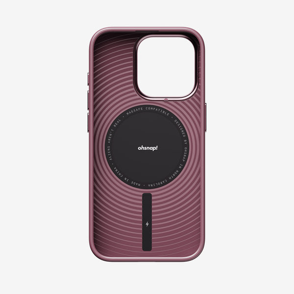Magenta phone case with a circular design and MagSafe compatibility, featuring a central logo and charging indicator.