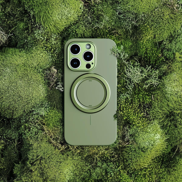 Green phone case with a circular magnetic attachment, placed on a bed of moss.