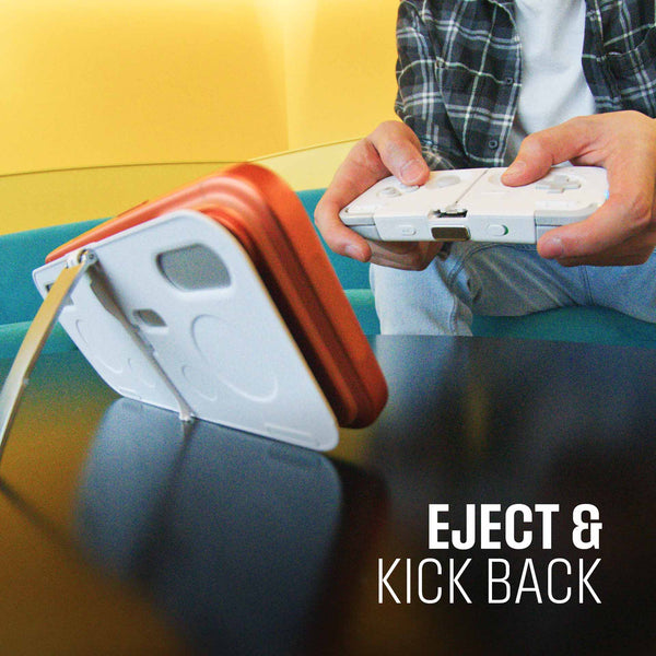 A person holds a gaming controller while a device stands on a table, showcasing a casual gaming setup.