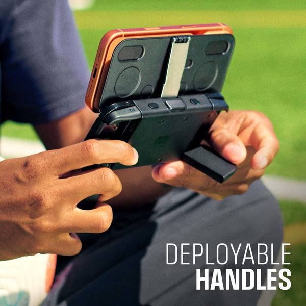 Hands holding a device with deployable handles, set against a grassy background.