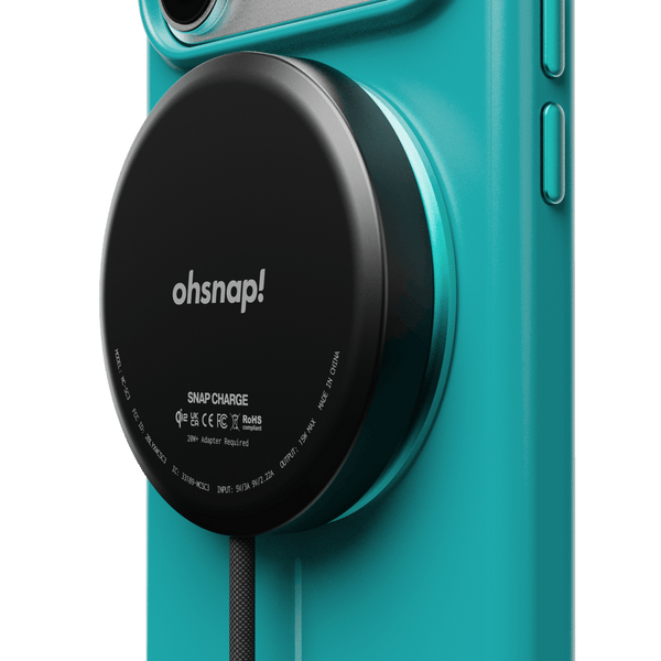 Teal phone case with a circular black charging pad attached, featuring the text 