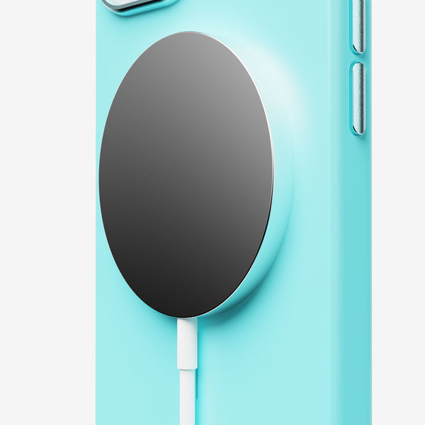 A turquoise phone case with a black circular magnetic charging pad attached.