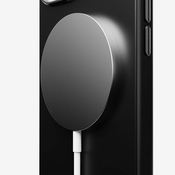 Magnetic charger attached to a black phone case, with a white charging cable connected.