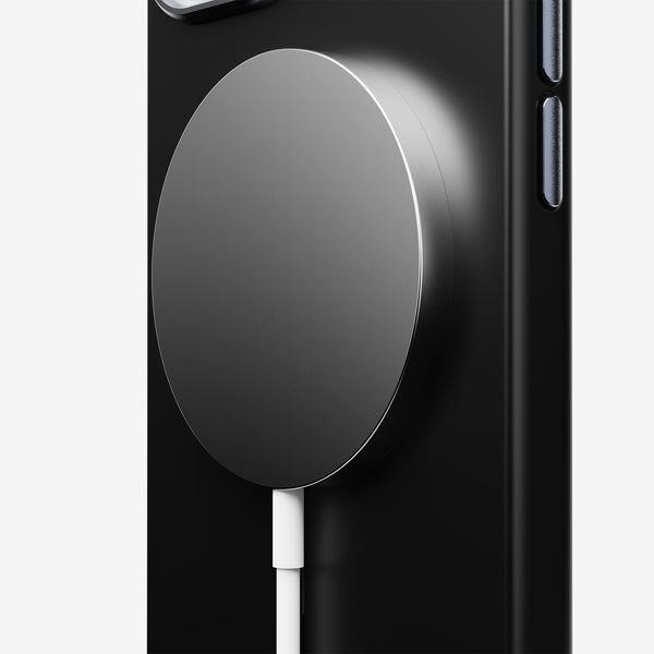 Black phone case with a circular magnetic charging pad attached, featuring a white charging cable.