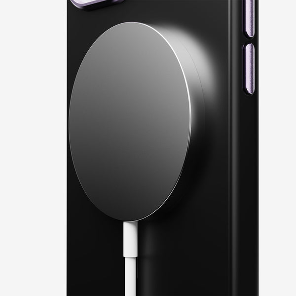 Magnetic charging pad attached to a black phone case with a white charging cable connected.