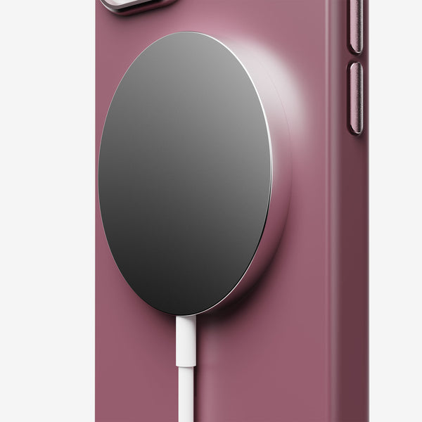 Close-up of a purple phone case with a circular magnetic charger attached.