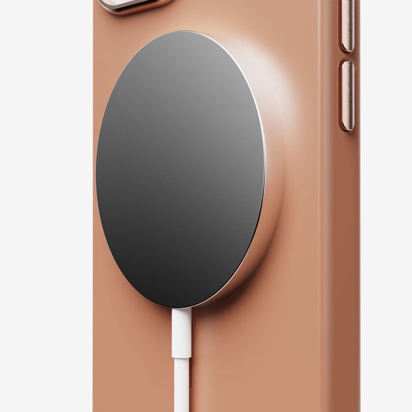 Close-up of a snap case with a magnetic charging pad attached, featuring a beige background and a white charging cable.