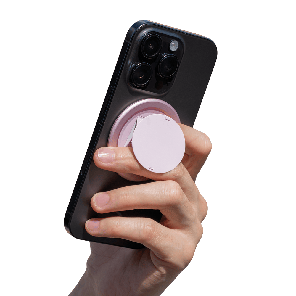 Hand holding a smartphone with a pink circular grip attached to the back.