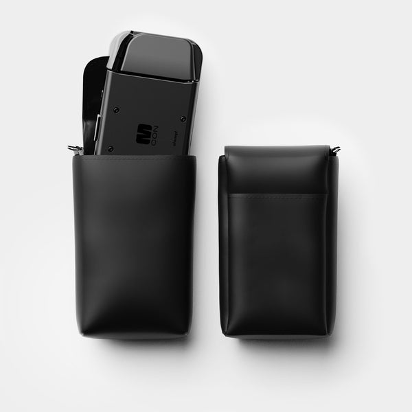 Two black travel sleeves, one containing a device, with a smooth finish and zip closures.