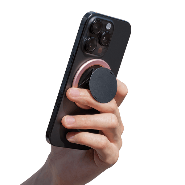 Hand holding a smartphone with a circular grip attached to the back.