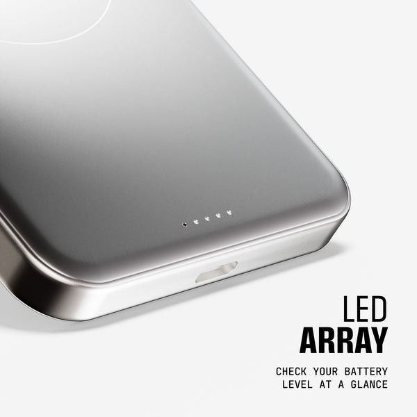 Close-up of a silver portable charger with an LED battery level indicator and a charging port.