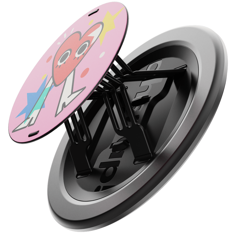 A circular phone grip with a pink design featuring a heart and stars, attached to a black base.